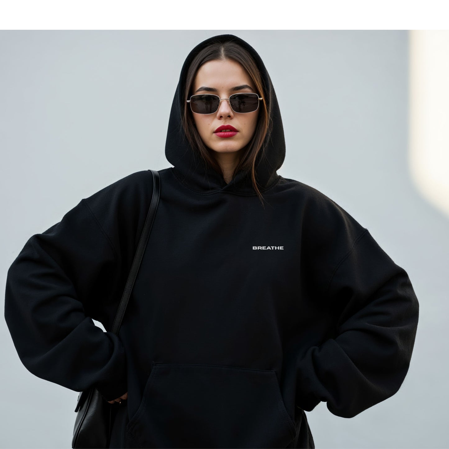 Model wearing black oversized VIKA & EVE  BREATHE hoodie – minimalist unisex design for who we strive to be.