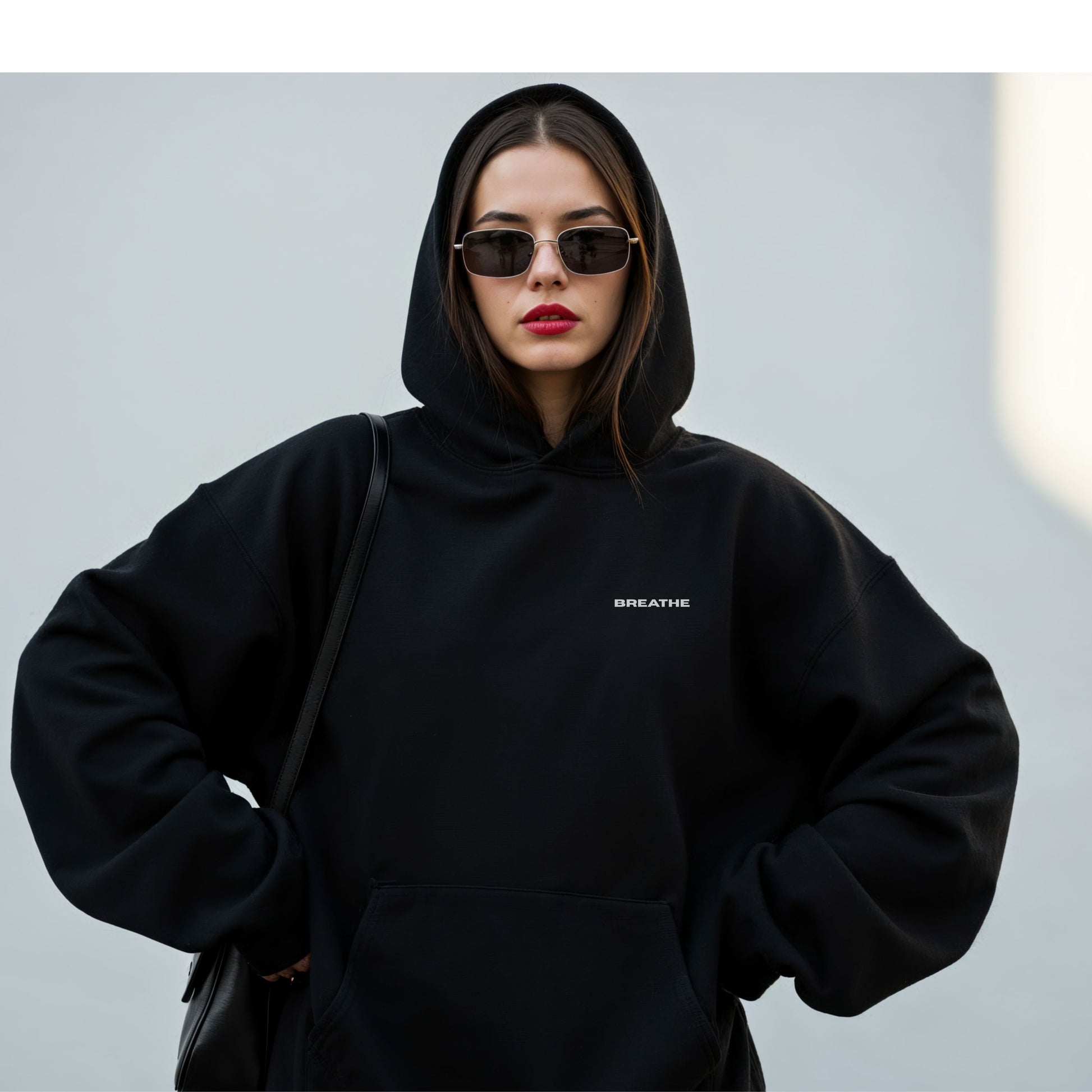 Model wearing black oversized VIKA & EVE  BREATHE hoodie – minimalist unisex design for who we strive to be.